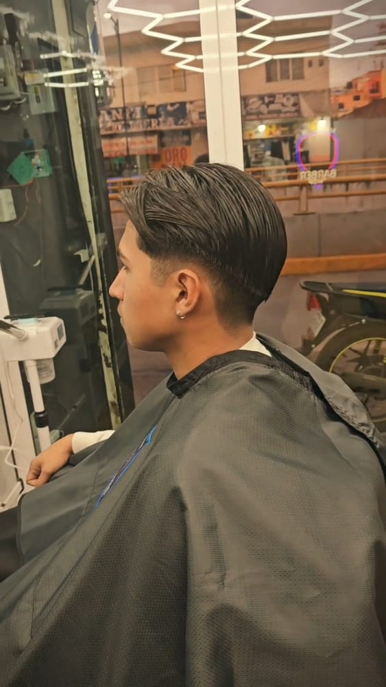 Corte con peinado lateral y fade bajo
