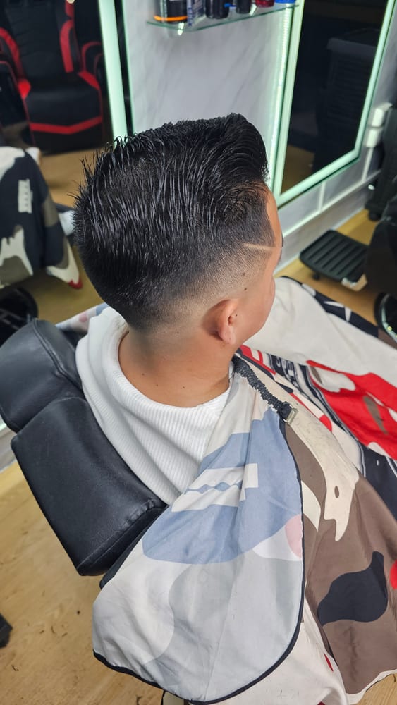 Fade alto con líneas marcadas y peinado en punta