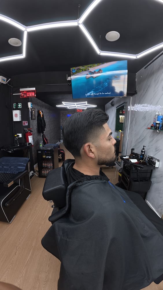 Corte clásico con fade bajo, vista de perfil en local premium