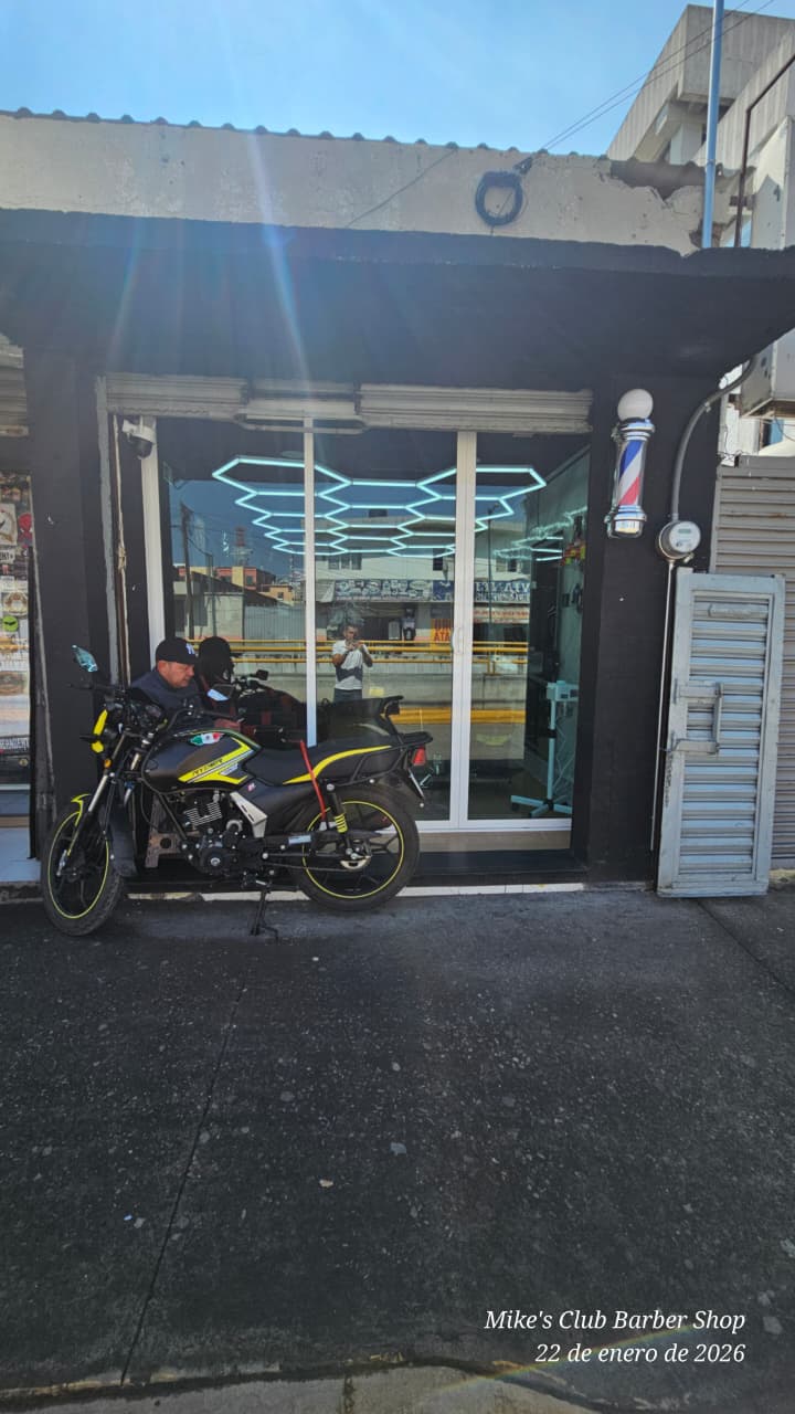 Fachada Mike's Club con barber pole tradicional